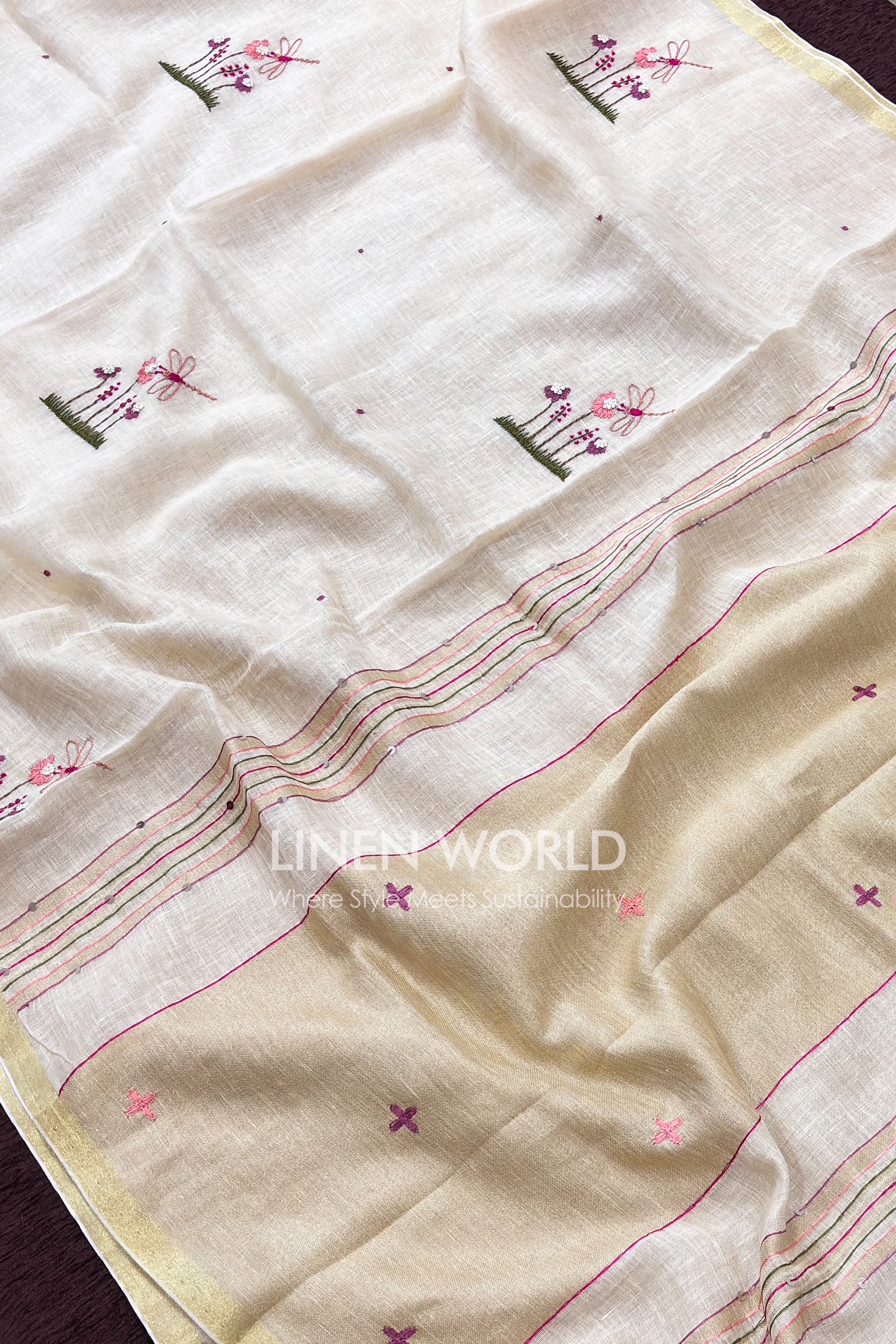 Off-white pure linen saree with gold zari border and hand embroidered floral design for Onam by Linen World
