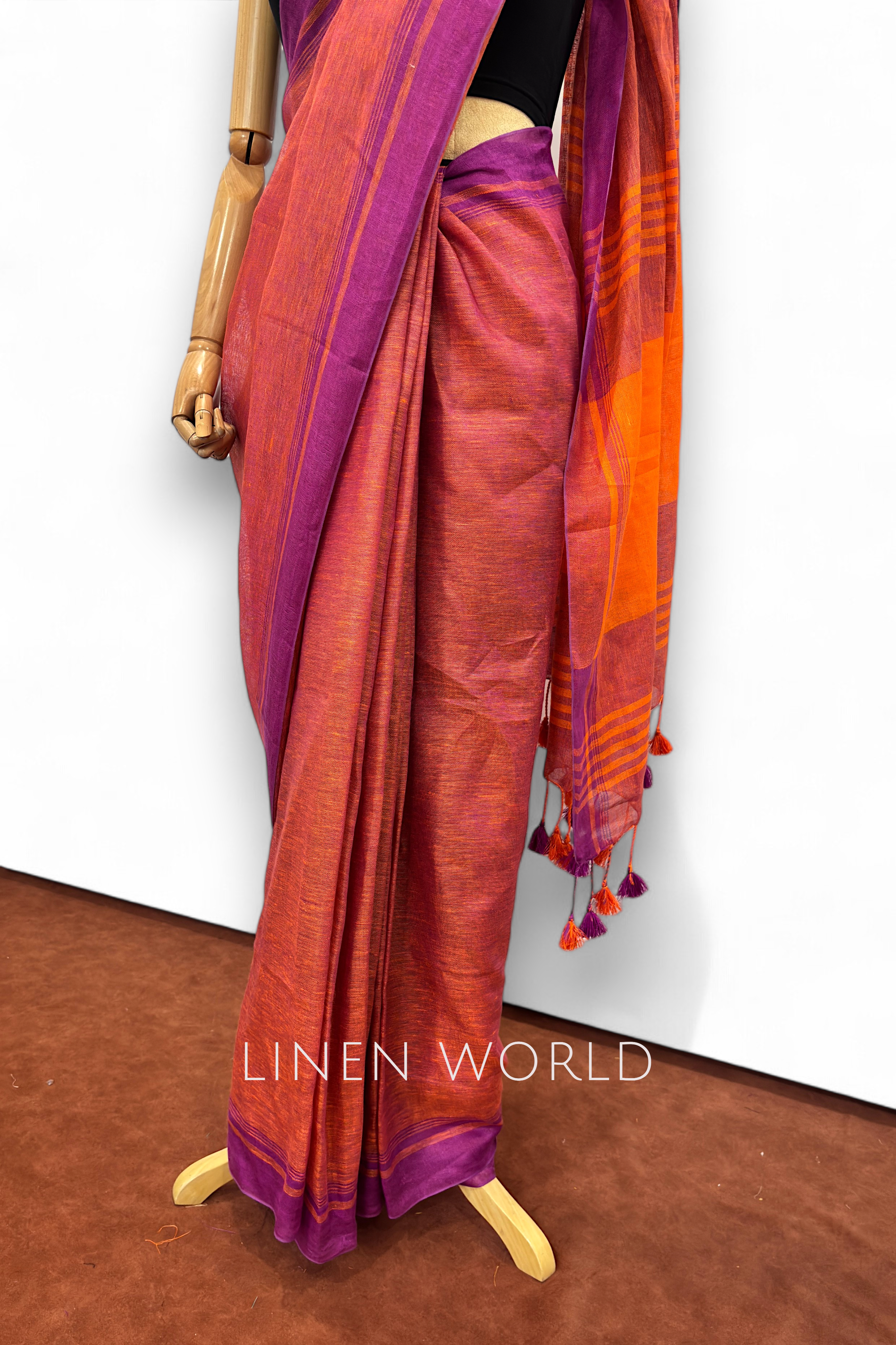 Office and daily wear purple linen saree with tassels branded 'Linen World'.