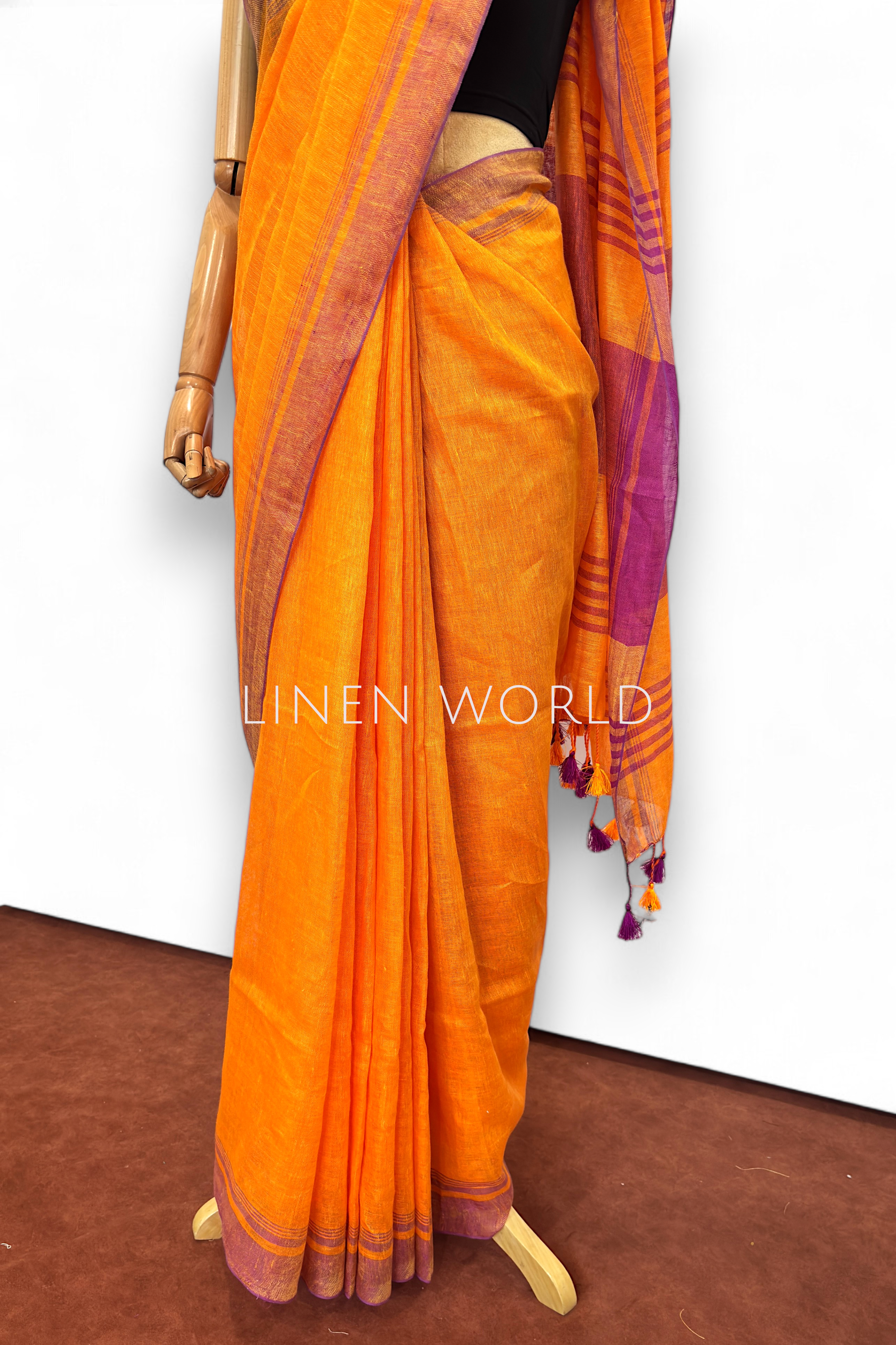 Office and daily wear orange linen saree with beautiful pleats and tassels, branded 'Linen World'.