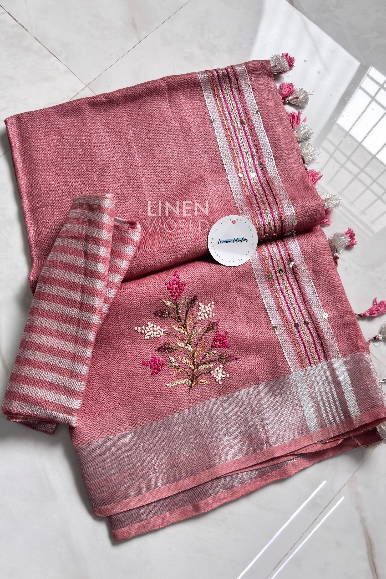 Pink linen saree pallu showing intricate hand embroidery - Linen World