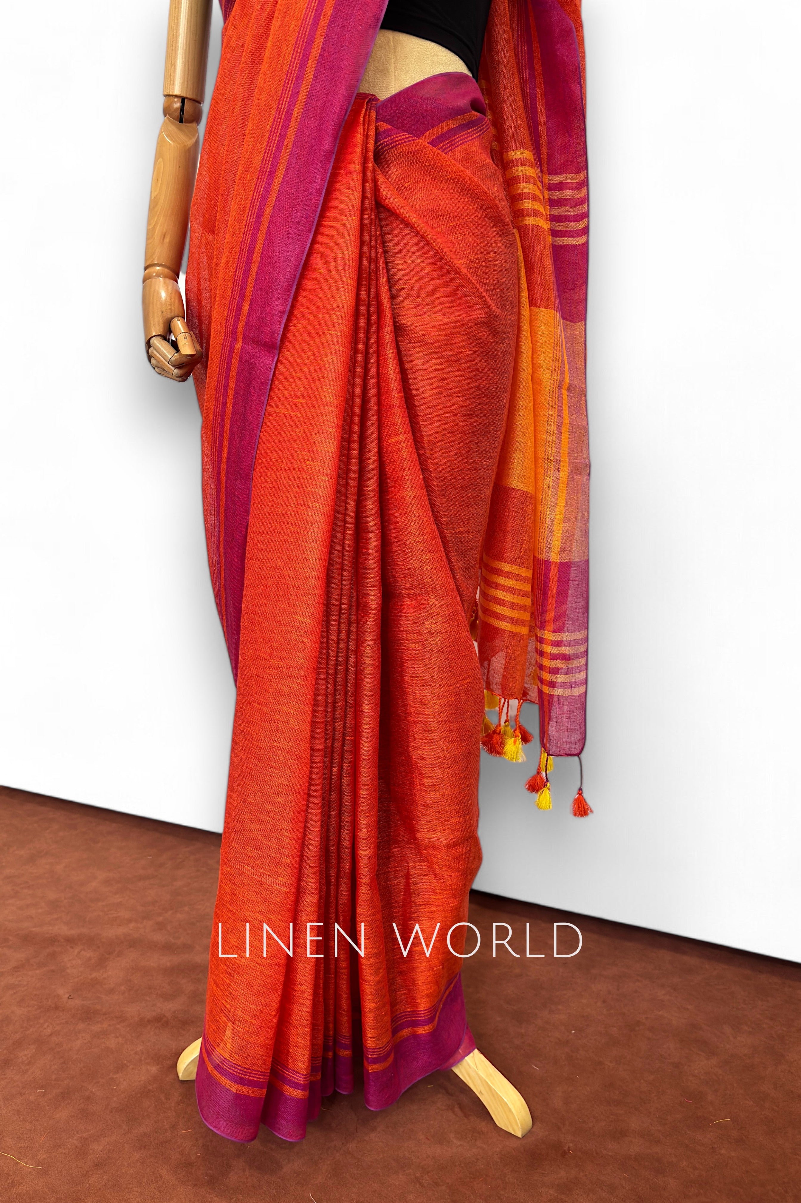 Office wear red linen saree with tassels and pleats branded 'Linen World'.