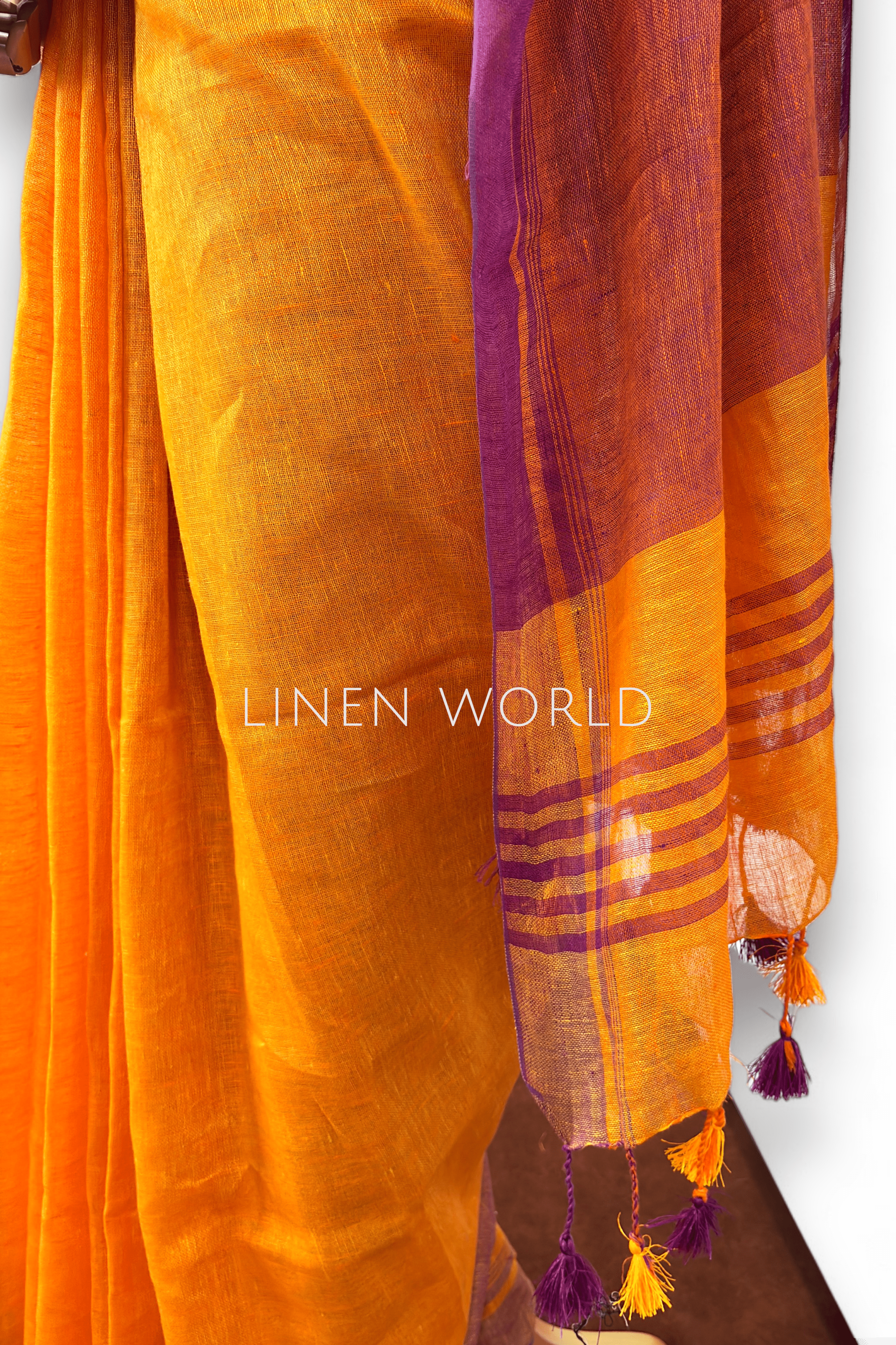 Office and daily wear orange linen saree with tassels branded 'Linen World'.