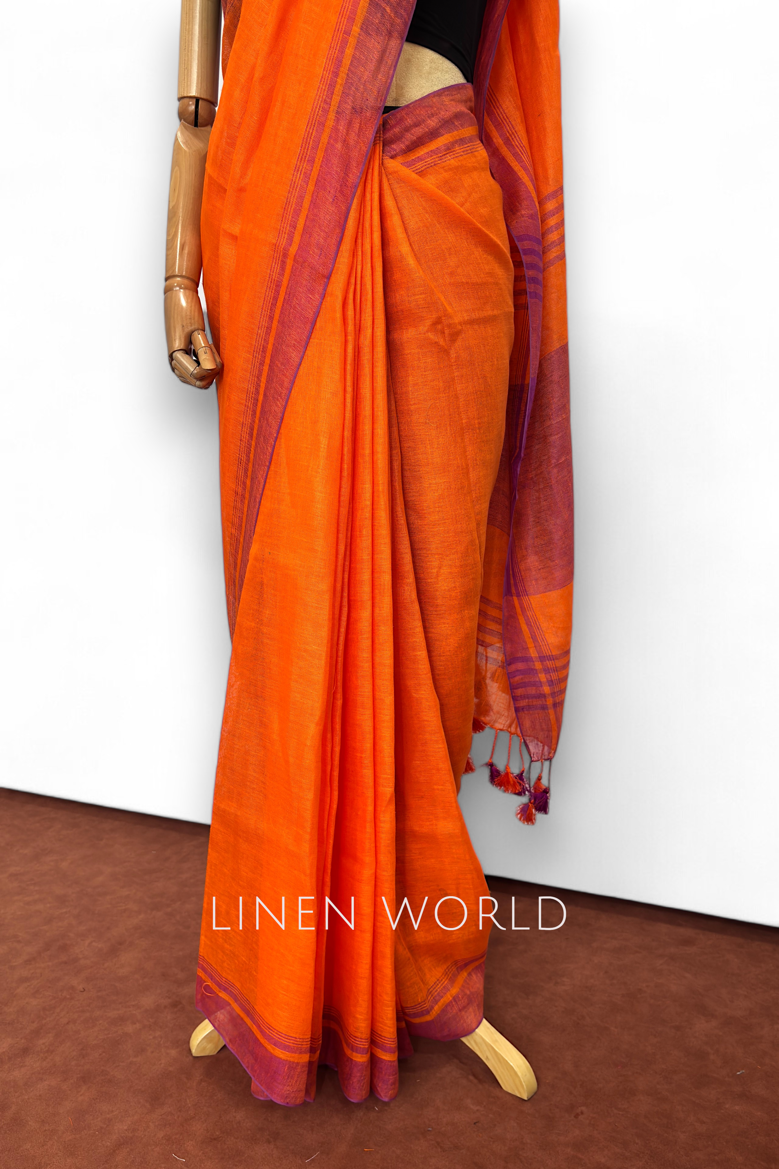 Soft and breathable dark orange linen saree with a classic border.