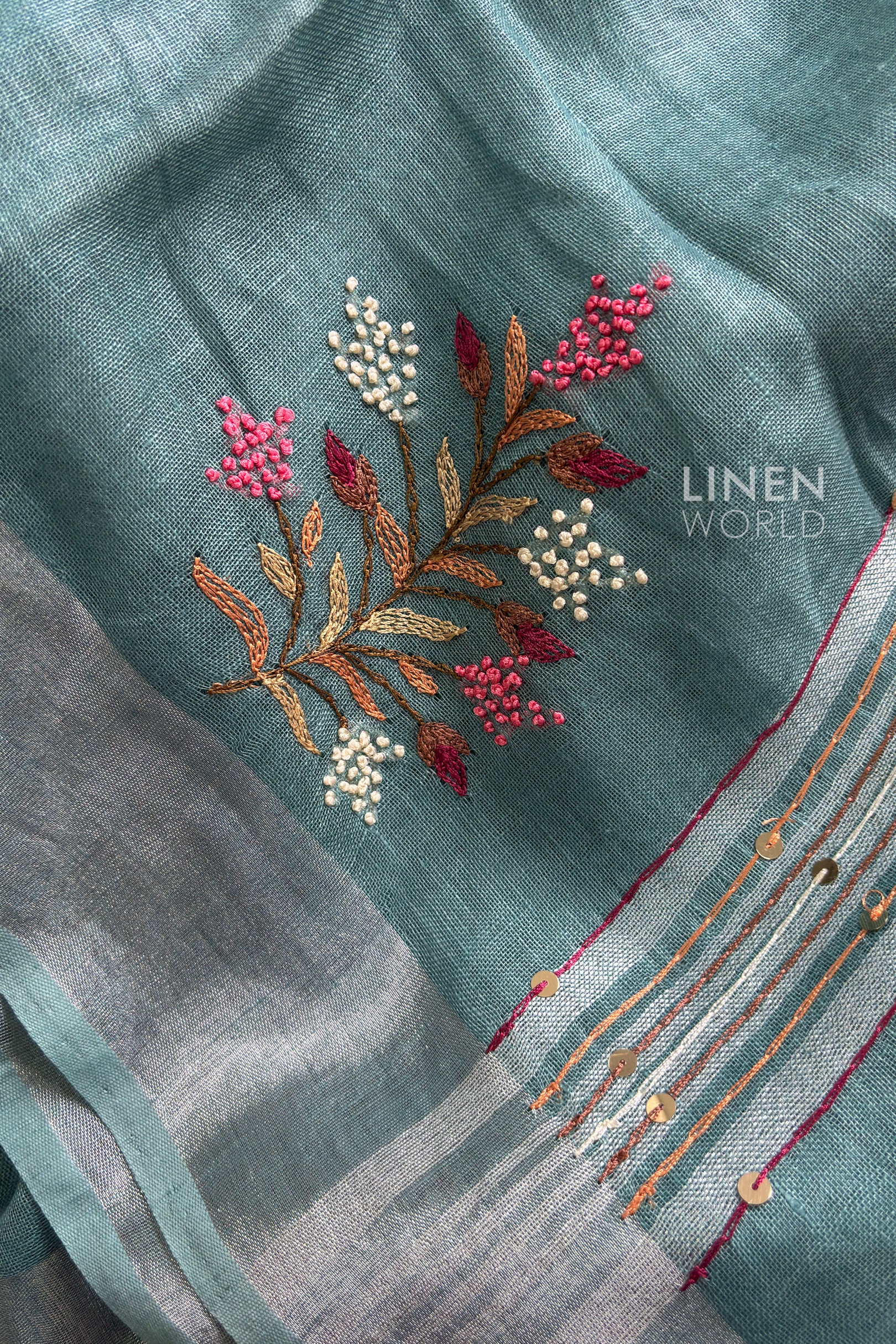 Close-up of French knot hand embroidery on teal blue pure linen saree by Linen World
