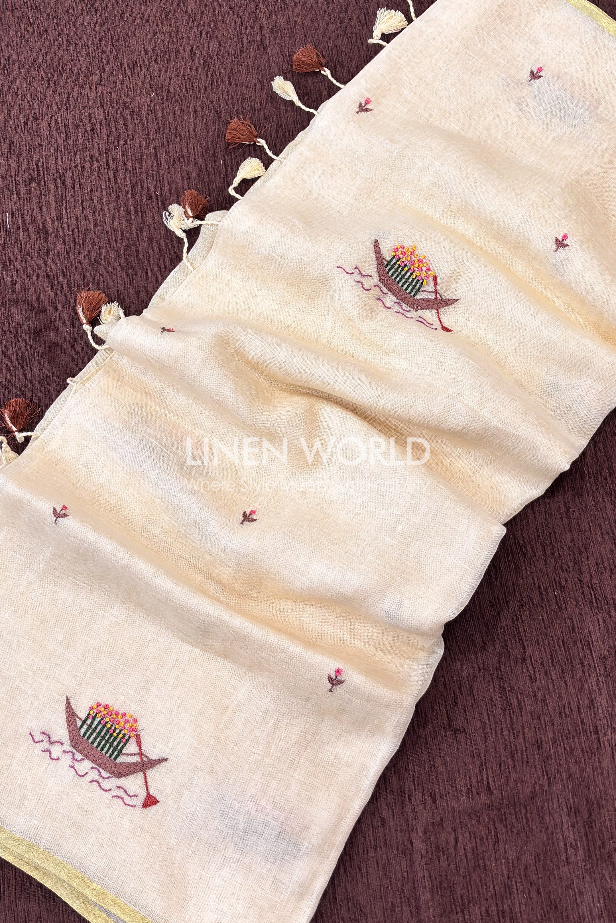 Close-up of hand embroidered boat filled with pink and yellow flowers on cream linen saree, Onam 2026 by Linen World