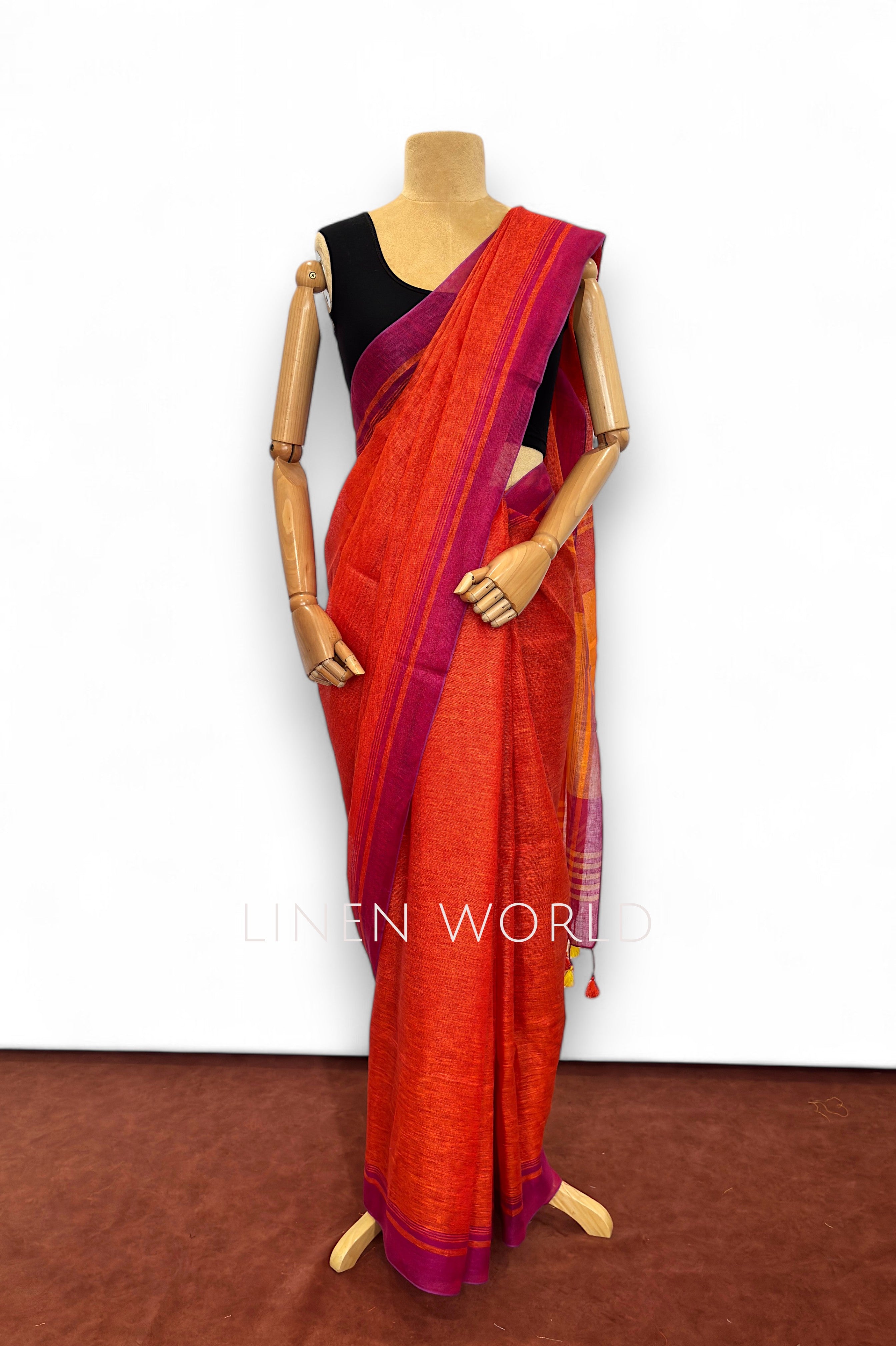 Office wear red linen saree with tassels branded 'Linen World'.