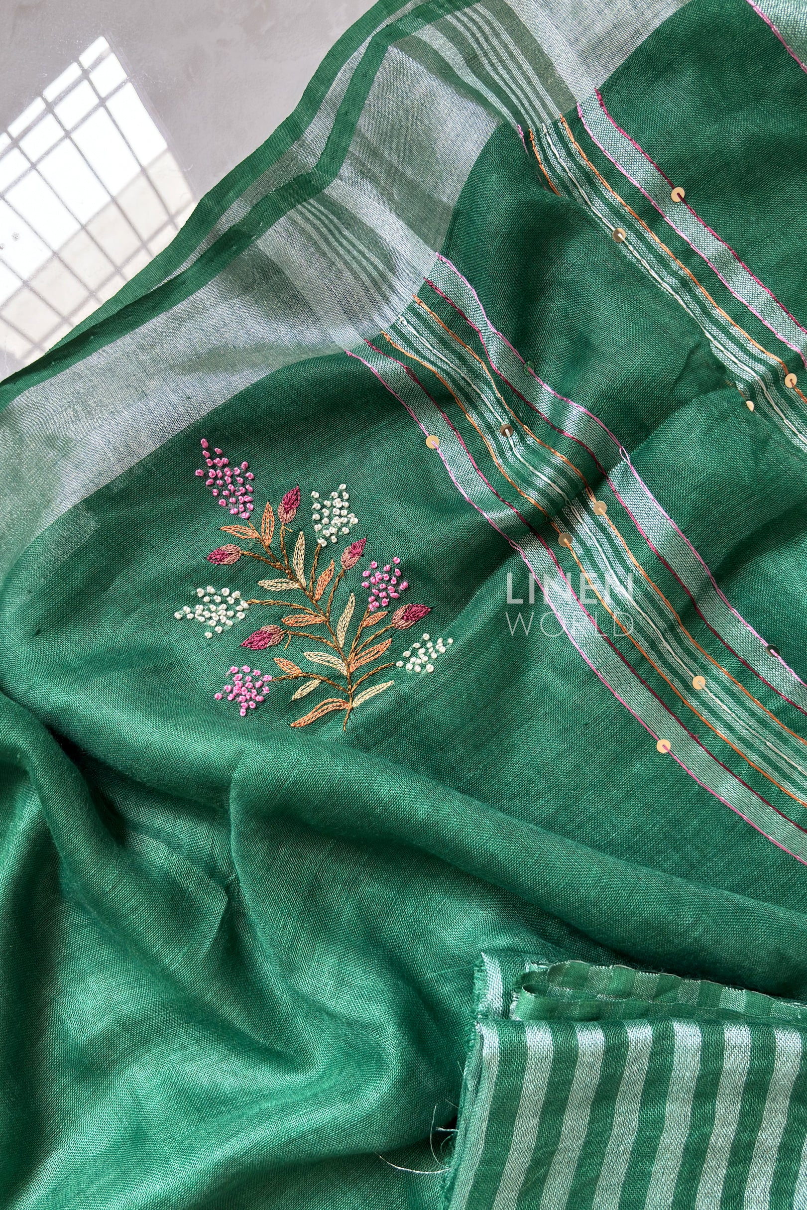 Close-up of French knot hand embroidery on green pure linen saree by Linen World