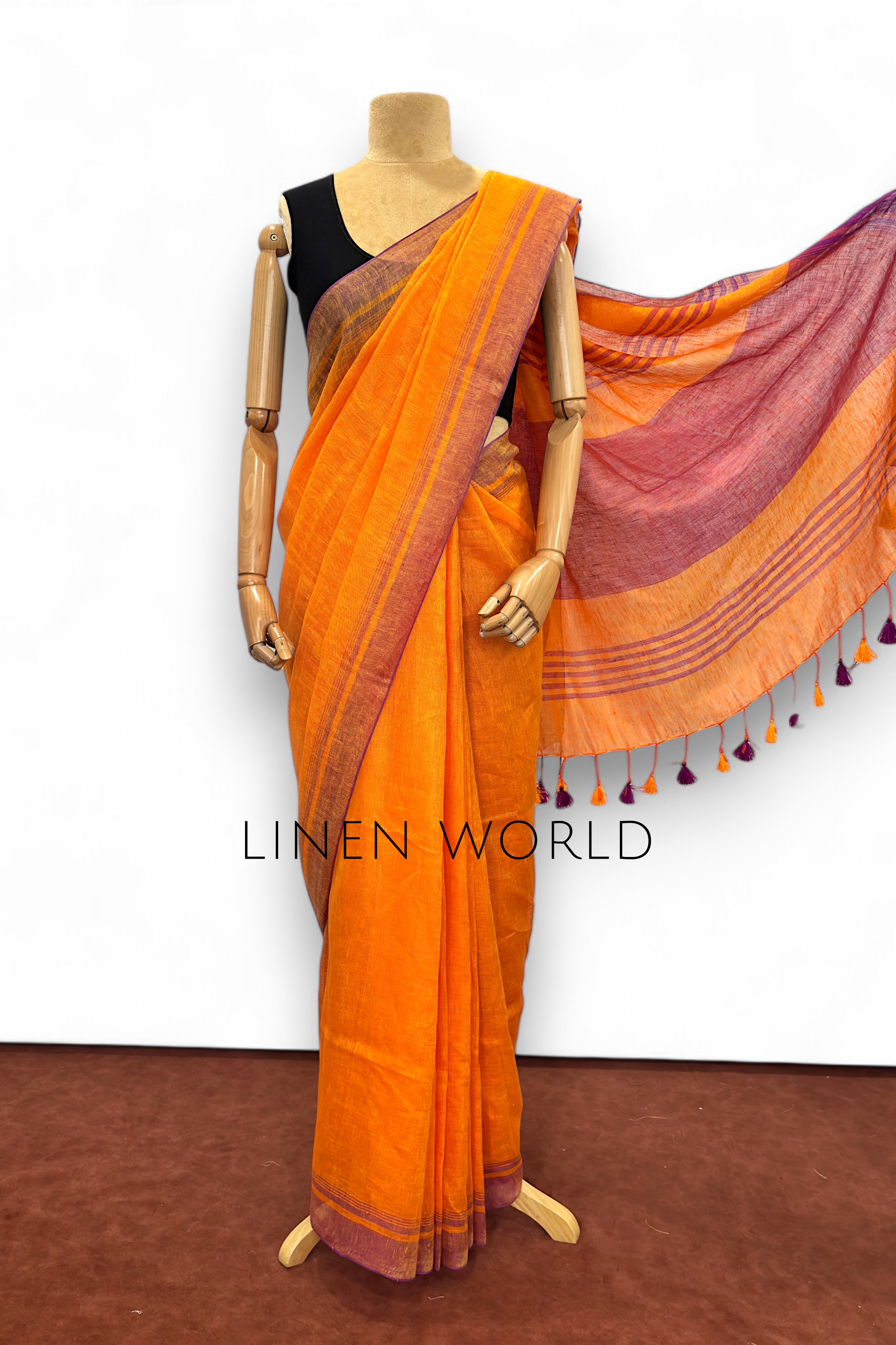 Office and daily wear orange linen saree with tassels branded 'Linen World'.