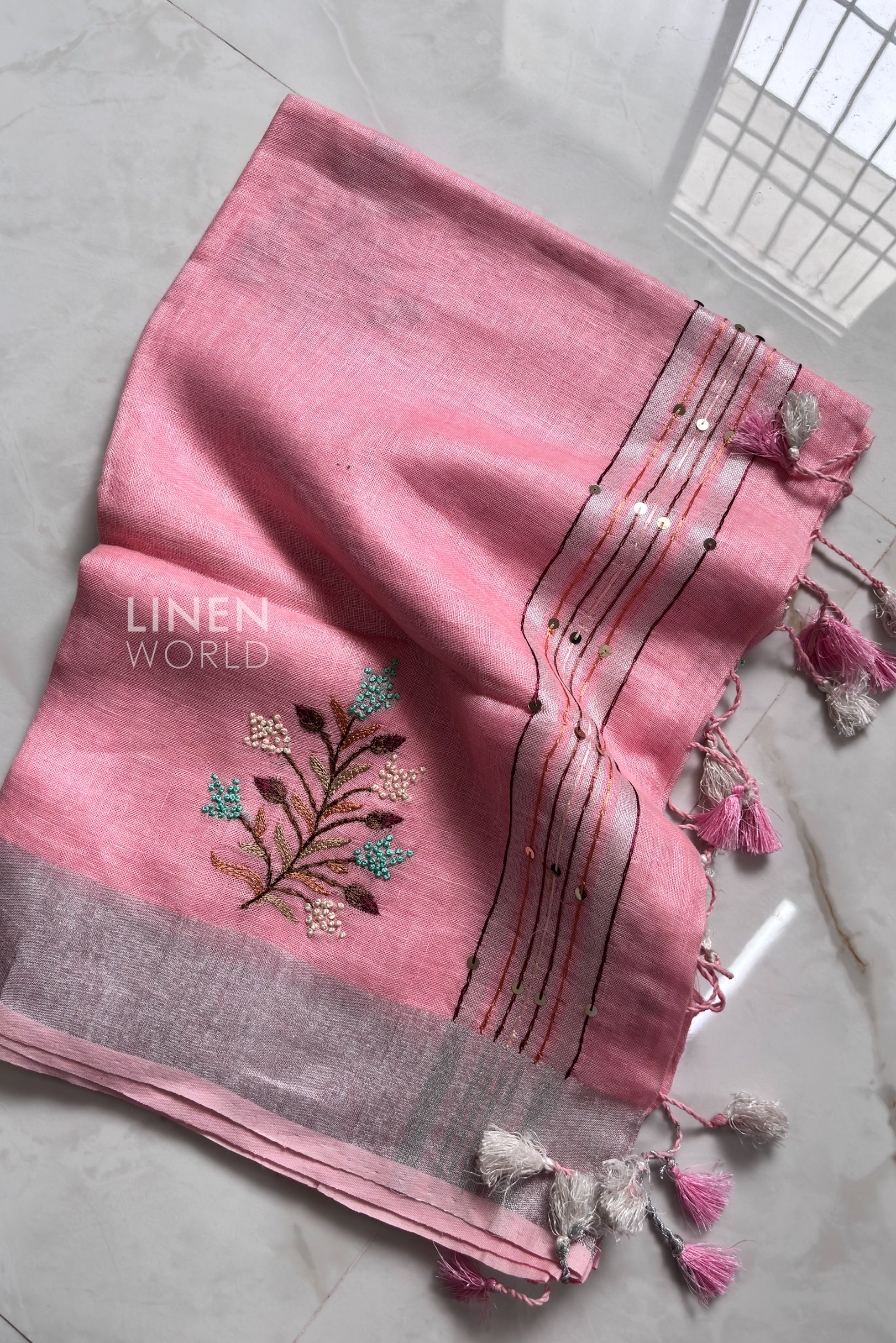 Pink linen saree pallu showing intricate hand embroidery - Linen World