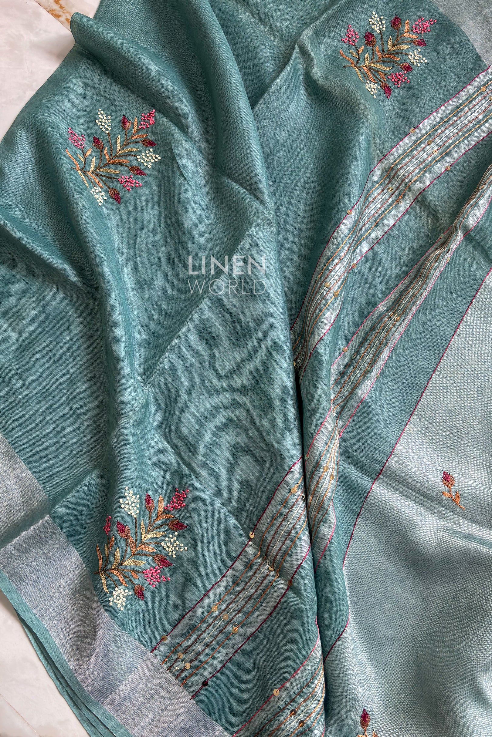 Close-up of french knot embroidery on teal blue pure linen saree by Linen World