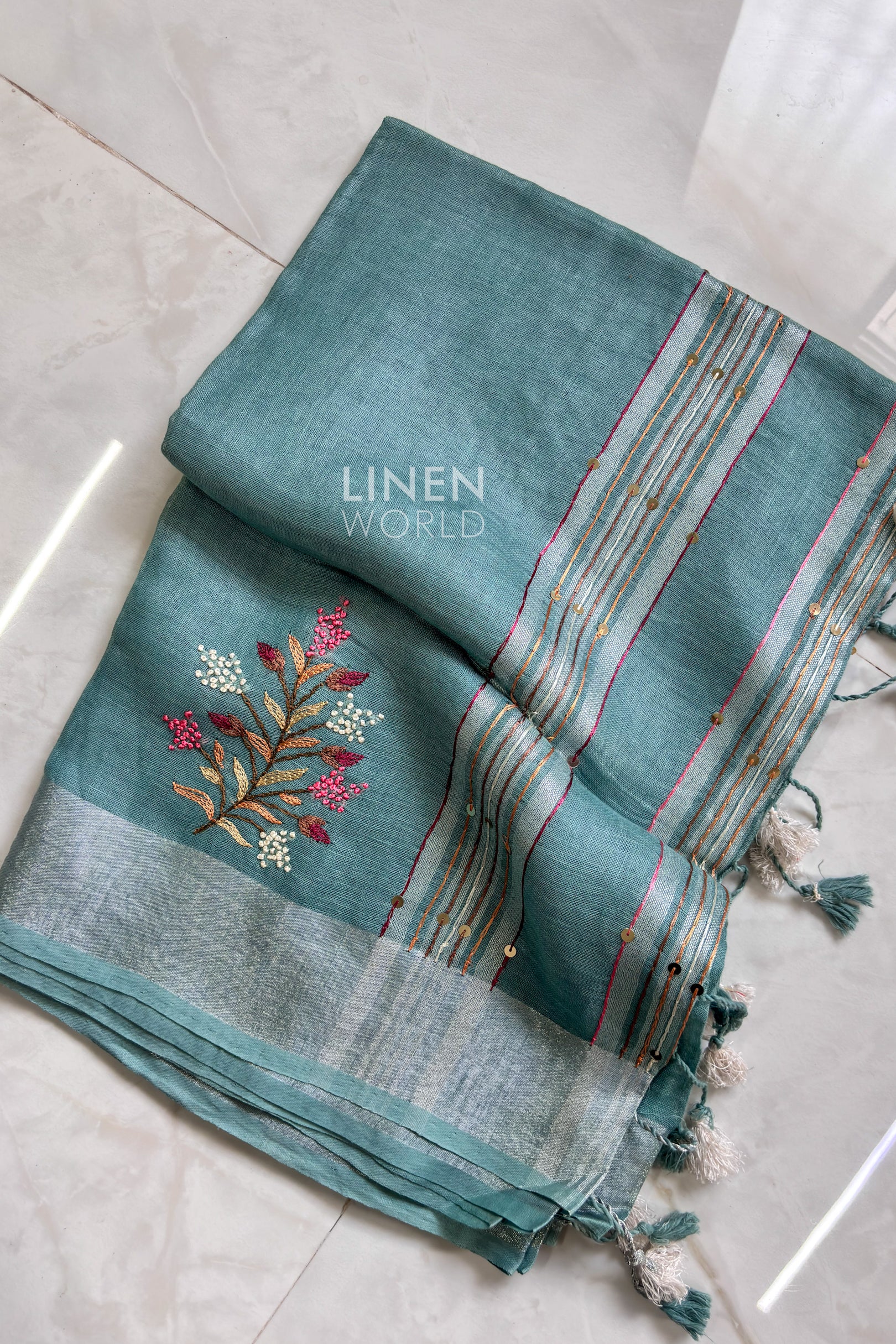Teal blue linen saree pallu showing intricate hand embroidery - Linen World