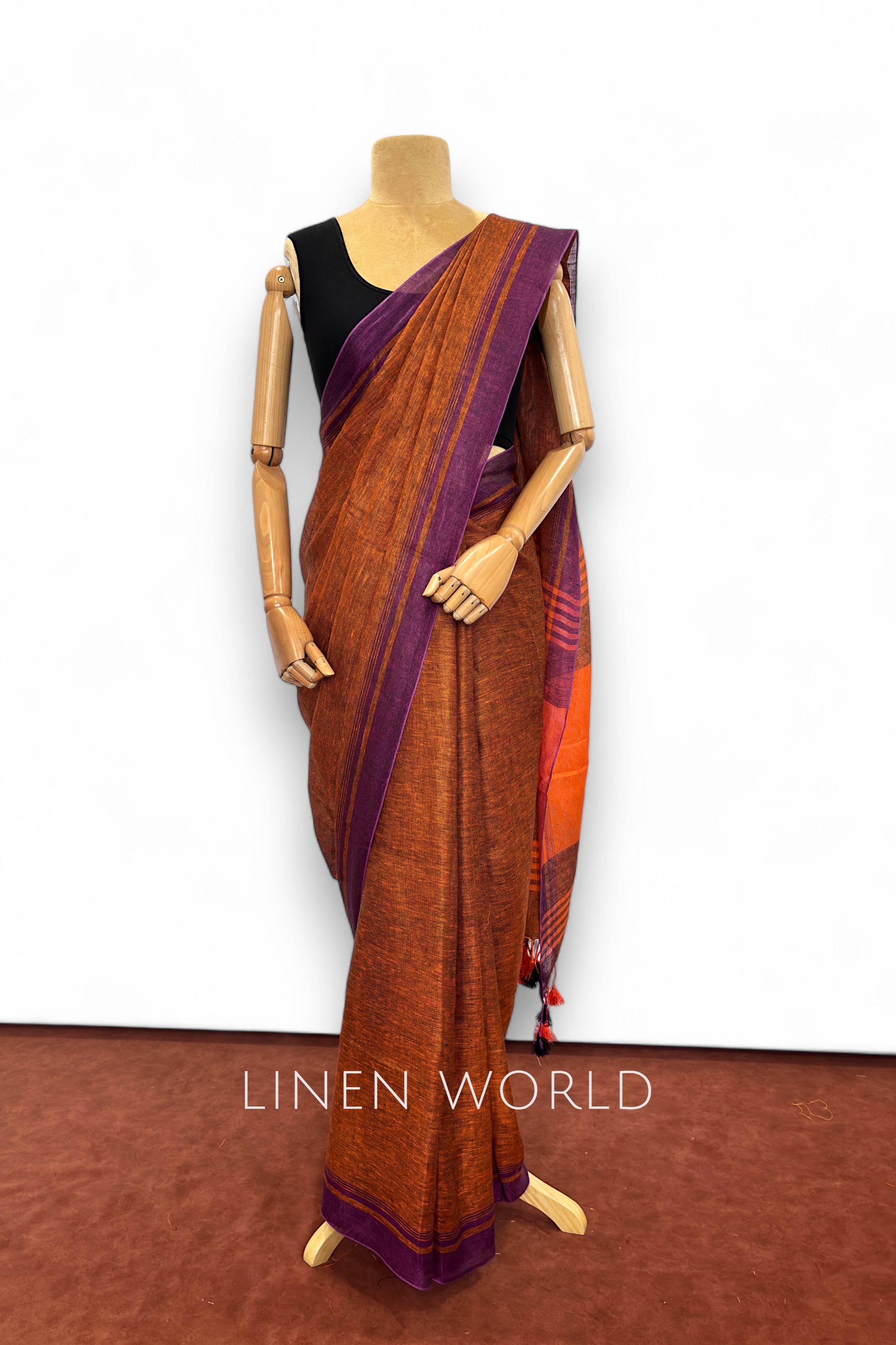 Office and daily wear brown linen saree with tassels branded 'Linen World'.